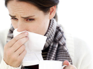Woman Holding a Mug with a Handkerchief to Her Nose --- Image by © Royalty-Free/Corbis